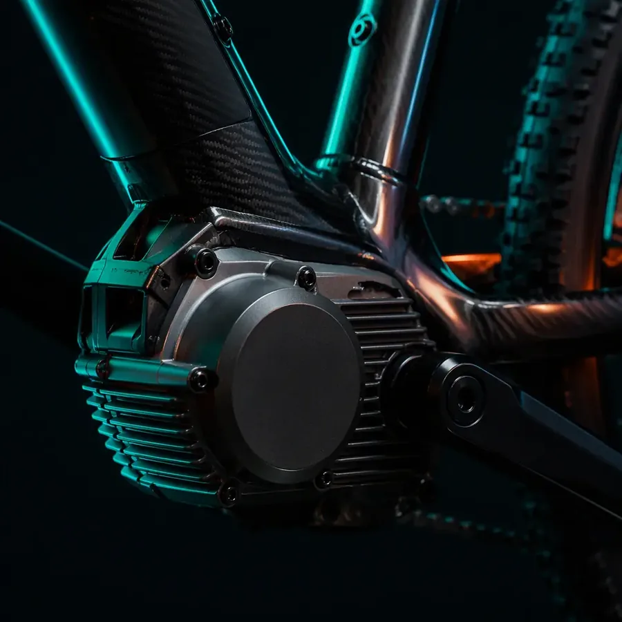 Close-up of a mid-drive motor at the bottom bracket with chainring and frame tubes