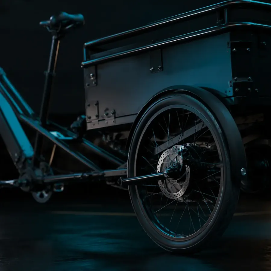 Close-up of a license plate and registration documents on the rear of an electric cargo tricycle at dusk