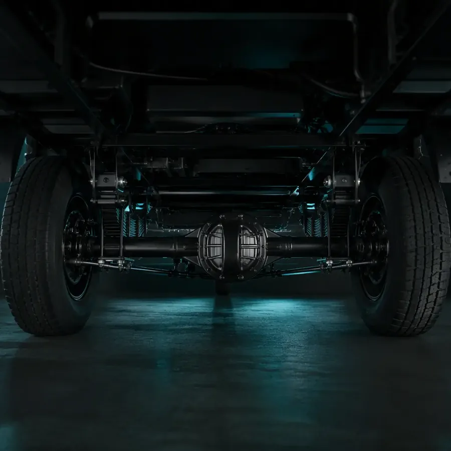 Rear axle of an electric cargo tricycle mounted in the steel chassis, showing the differential housing, axle tubes and dual load-rated rear wheels