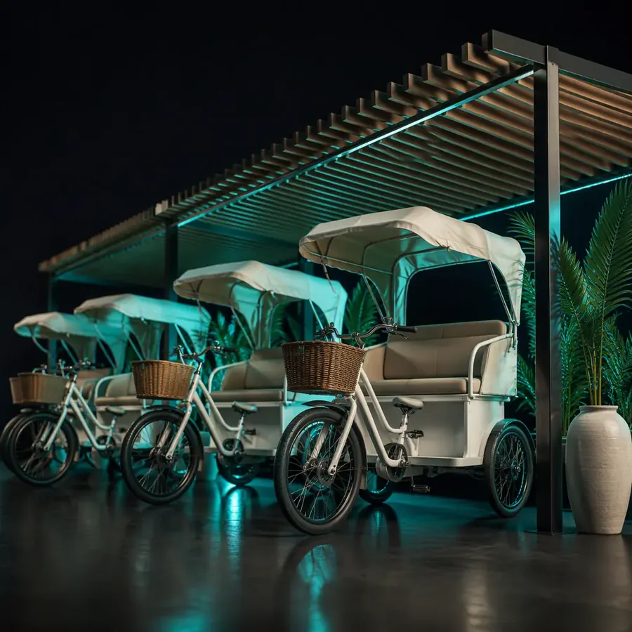 Tourist rental station with passenger tricycles parked under a canopy at a Mediterranean boardwalk